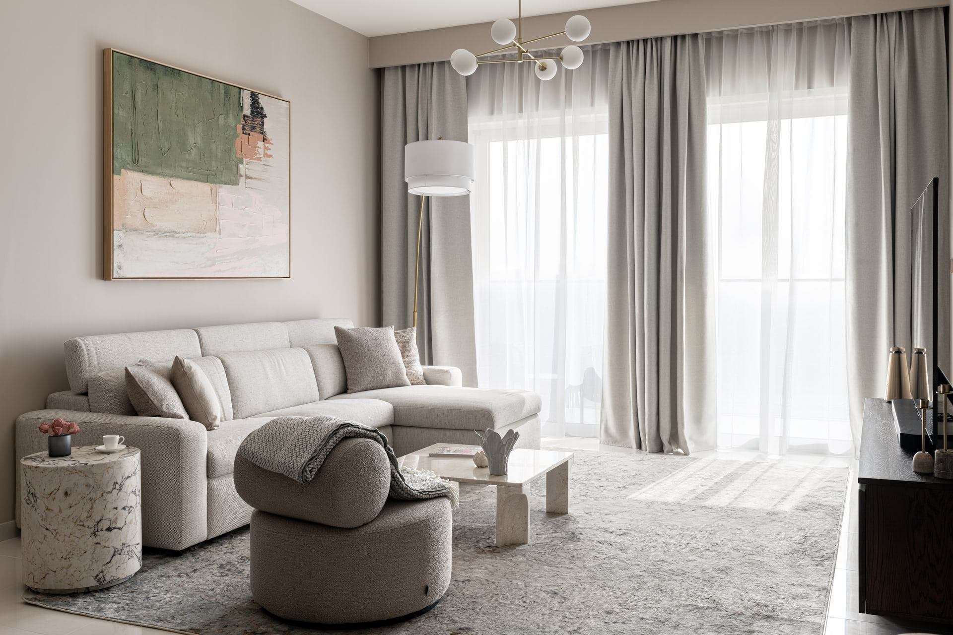 Dubai apartment living room with pale upholstery, marble tables and abstract art