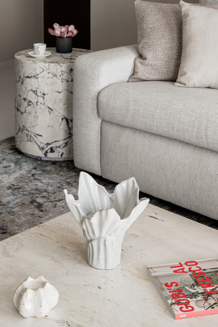 Stone side table and pale sofa detail