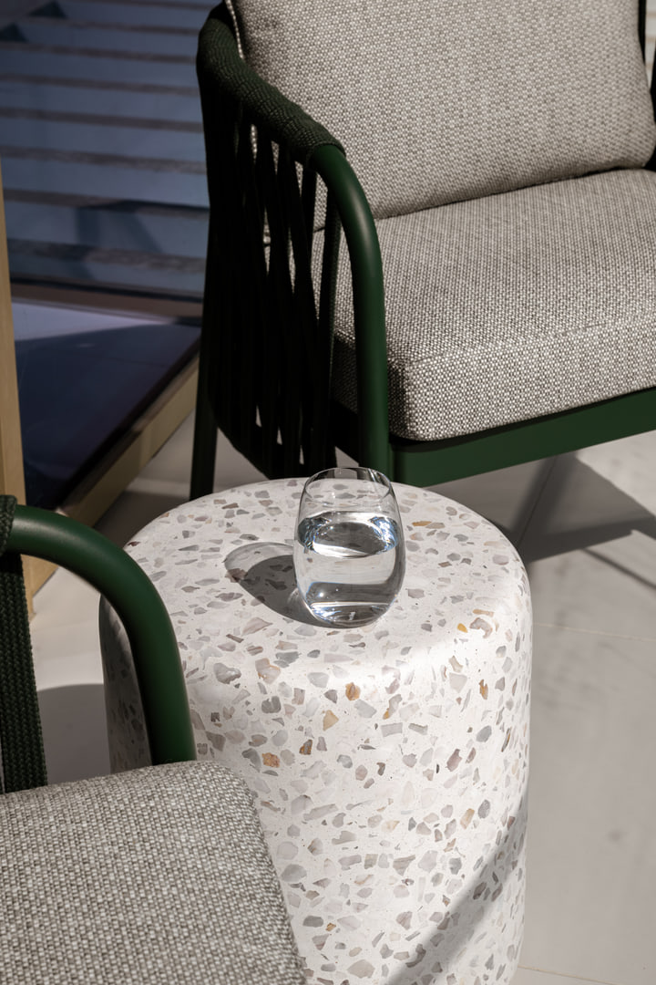 Green balcony chair beside a terrazzo table