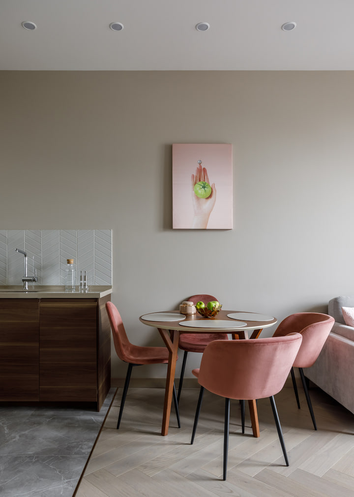 Dining area with pink chairs and walnut cabinet