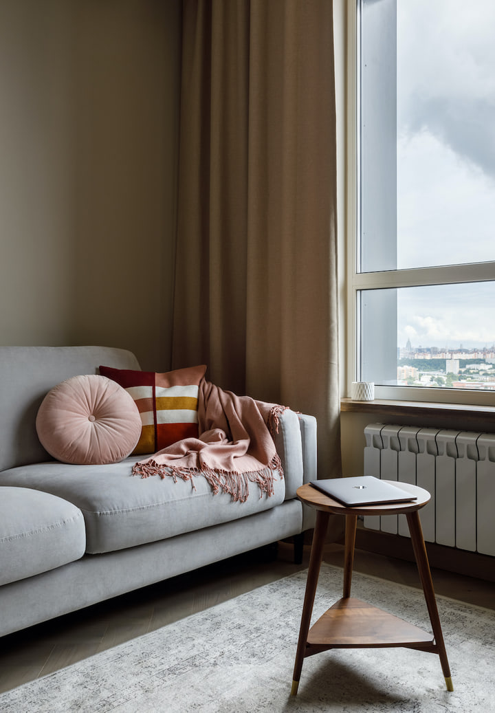 Sofa by the window with a round bolster cushion
