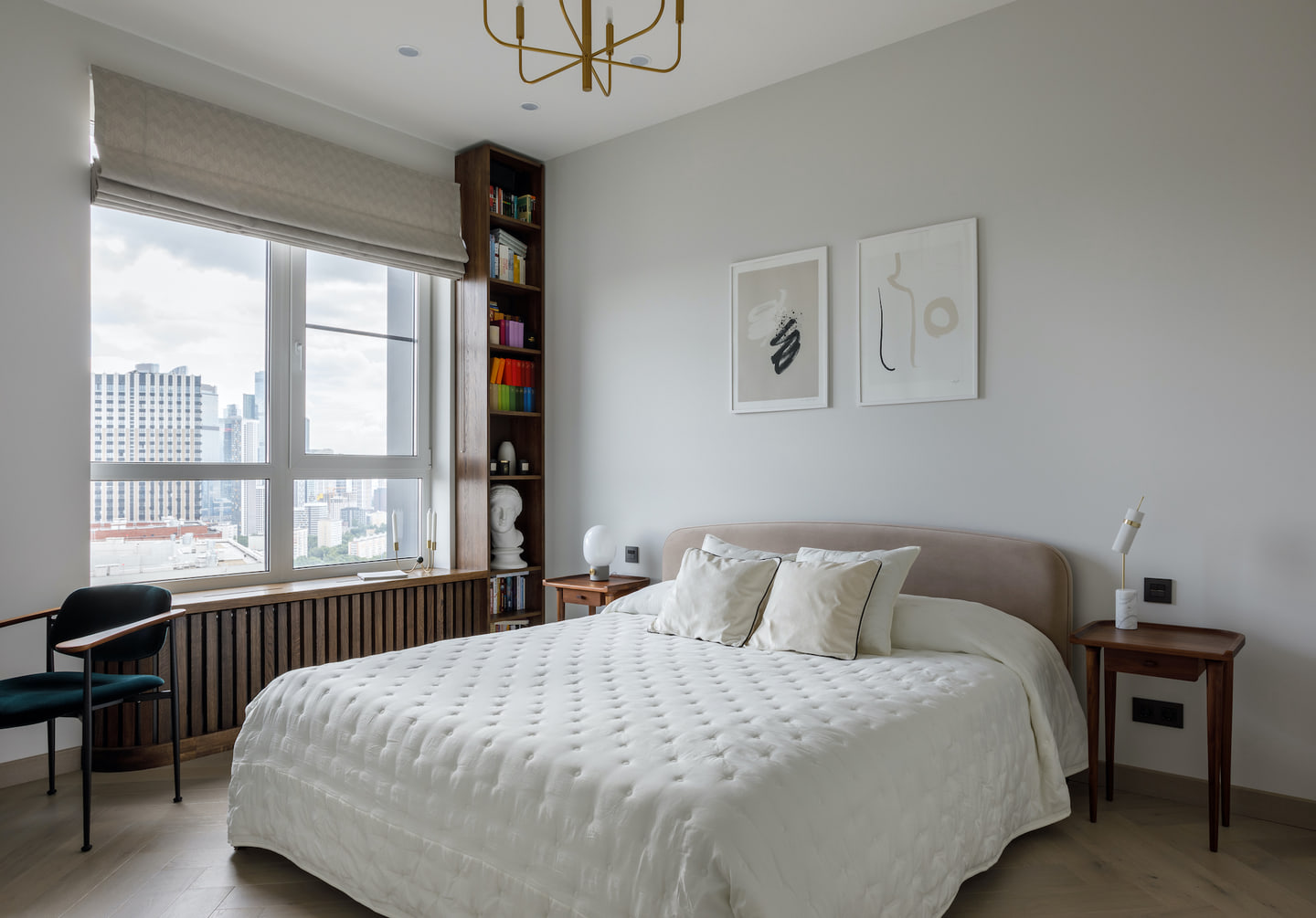 Moscow bedroom with pale upholstery, artwork and a desk by the window