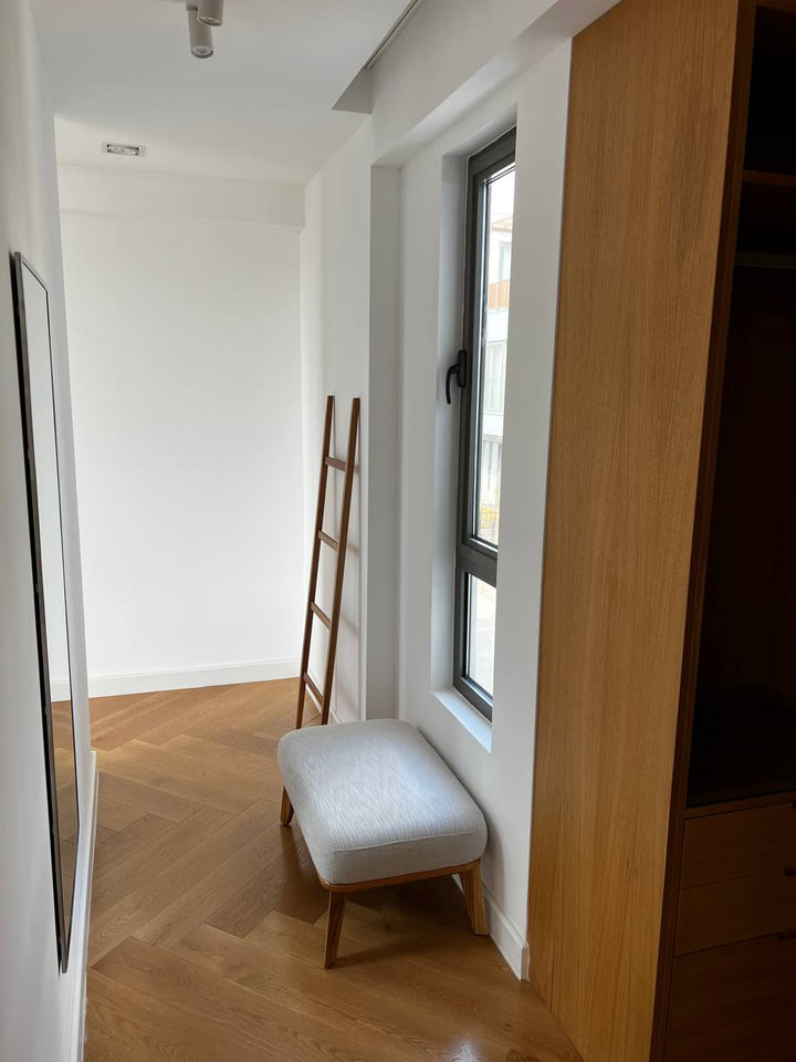Bedroom dressing passage with timber wardrobe and upholstered stool